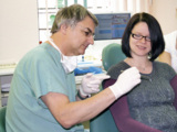 Dr. Hans-Dieter John führt den aMMP-8 Test bei einer schwangeren Patientin durch.