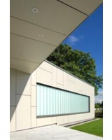Die transluzente Glaskonstruktion stellt einen farblichen Kontrast zur Fassade dar.