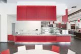 Die roten Wabenpaneele auf den Fronten der Großküchenmöblierung setzen einen farblichen Akzent.